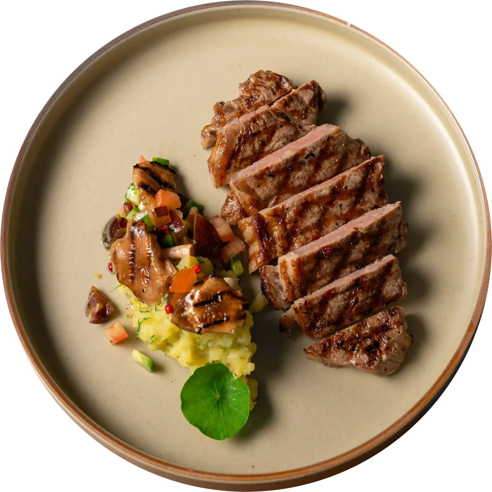 Stek z rusztu z puree ziemniaczanym i grillowanymi boczniakami na ceramicznym talerzu